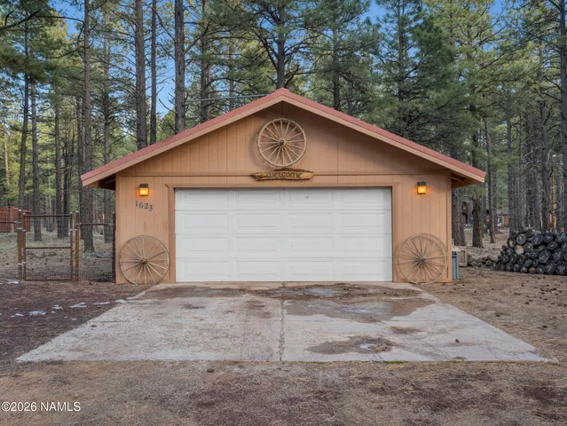 a backyard of a house with large trees and wooden fence