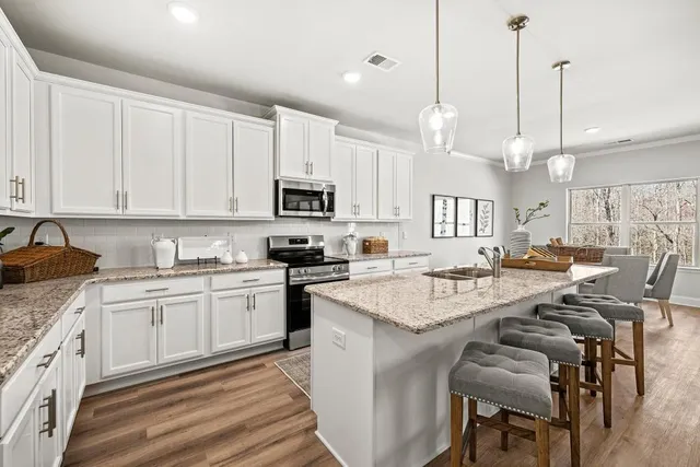 a large kitchen with kitchen island a island a sink a stove and a center island
