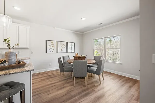 a dining room with furniture and wooden floor