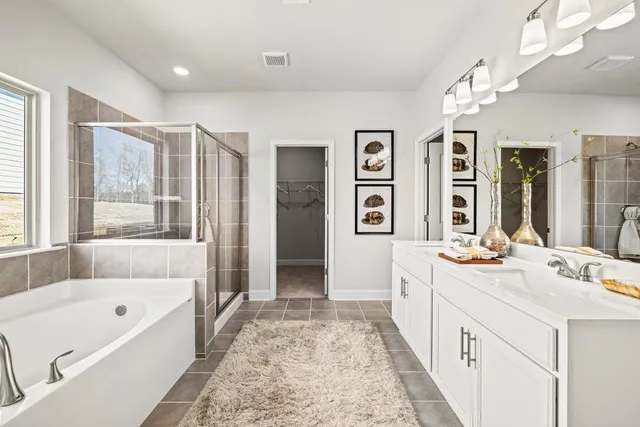 a bathroom with a tub a sink and a large mirror