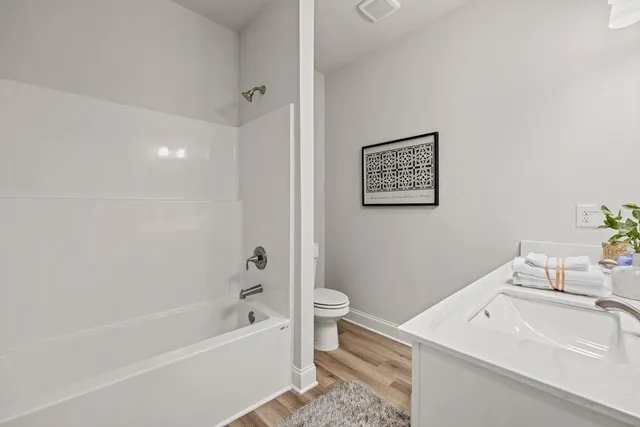 a bathroom with a white bath tub a sink and a toilet