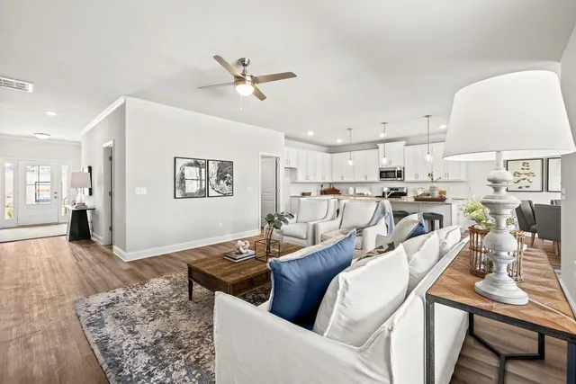 a living room with furniture and a wooden floor