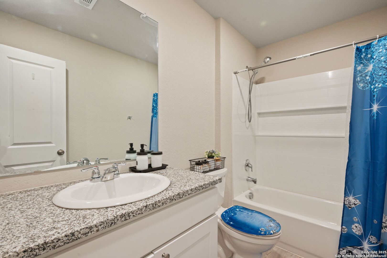 439 Agave Circle Jourdanton, TX 78026 - Photo 22 of 27 a bathroom with a granite countertop sink toilet mirror and shower