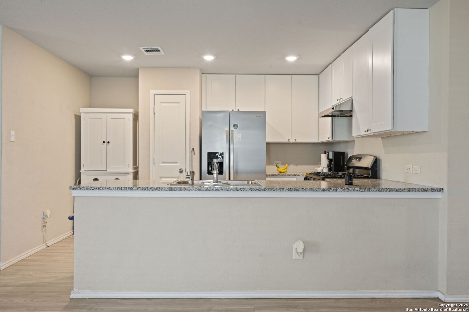 439 Agave Circle Jourdanton, TX 78026 - Photo 7 of 27 a kitchen with stainless steel appliances granite countertop a sink a stove and a refrigerator