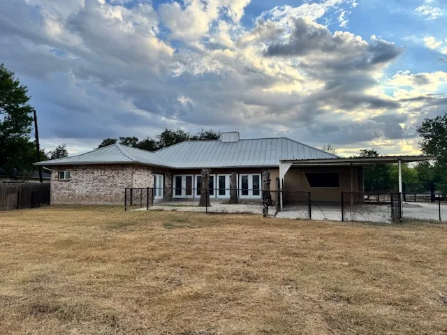a backyard of a house with barbeque oven and outdoor seating