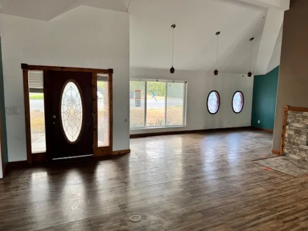 a view of a livingroom with wooden floor and a large window