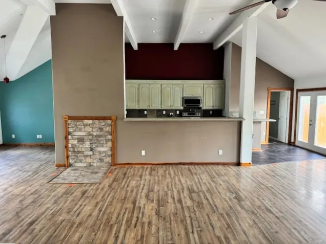 a kitchen with stainless steel appliances a sink cabinets and wooden floor