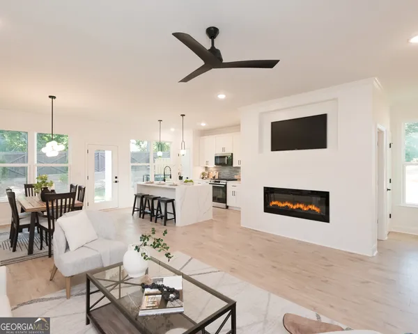 a living room with furniture a fireplace and a flat screen tv