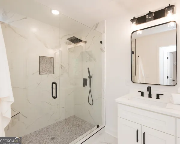 a bathroom with a shower sink and mirror