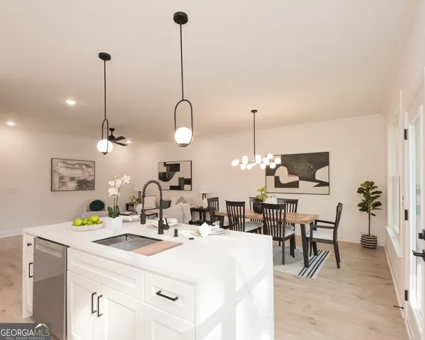a kitchen with a dining table chairs and white cabinets