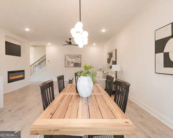 a view of dining room and livingroom with furniture wooden floor a rug a potted plant and a chandelier