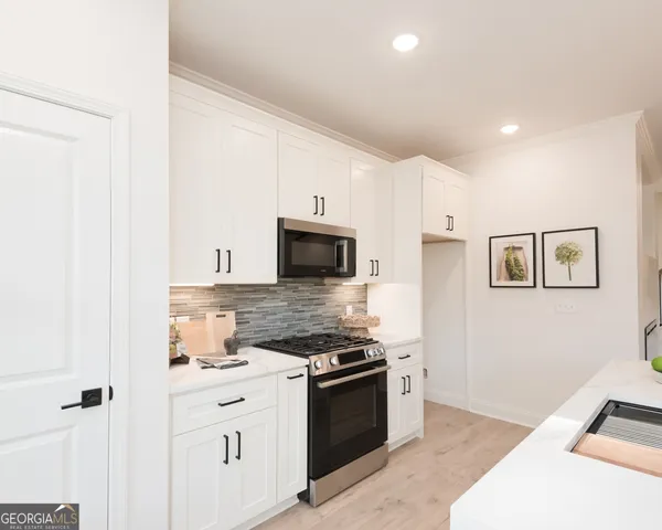a kitchen with stainless steel appliances white cabinets and a refrigerator