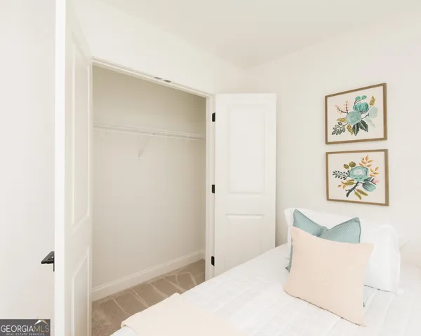 a bedroom with a bed and painting on the wall