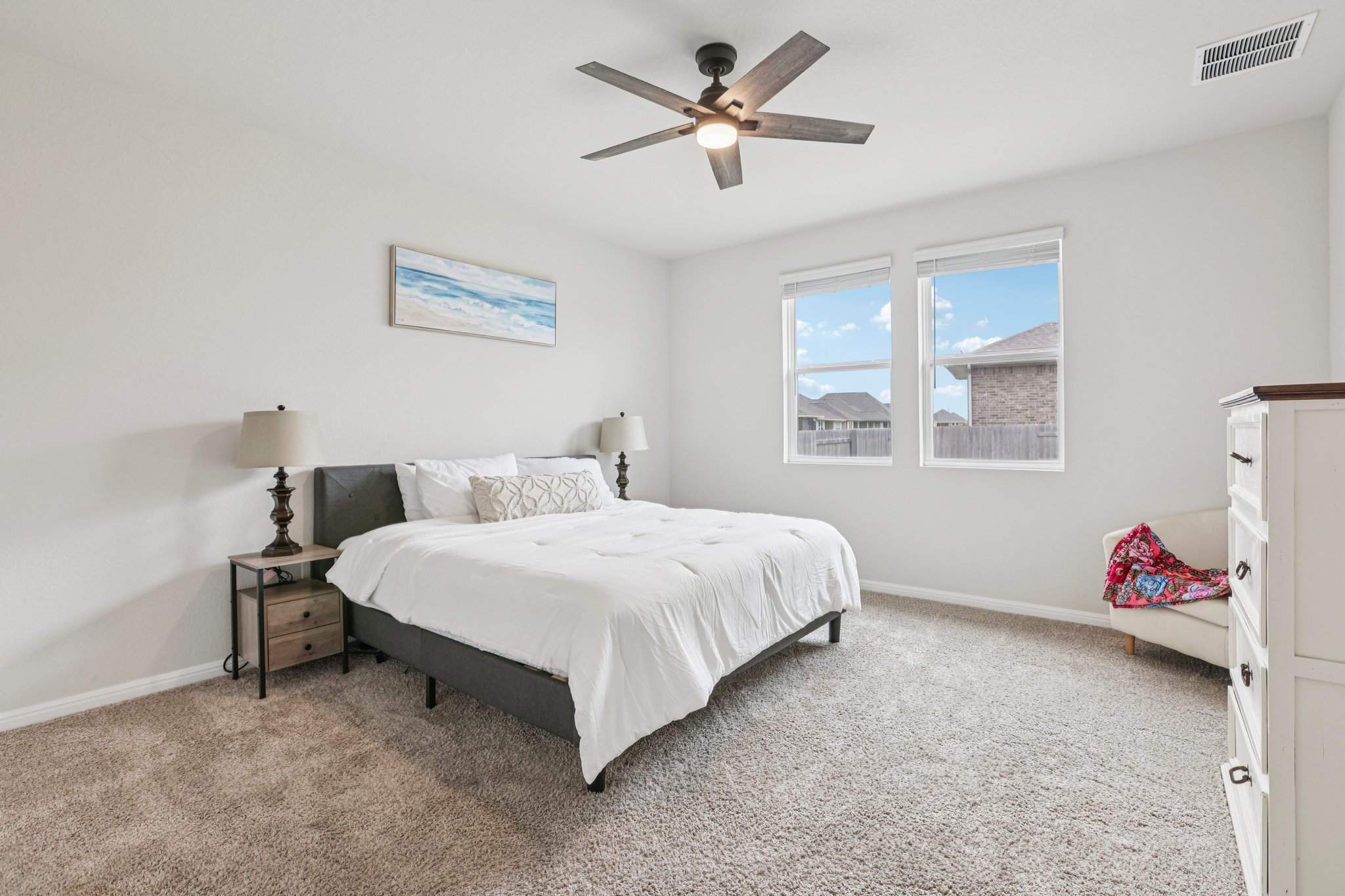 204 Swinging H Lane Georgetown, TX 78633 - Photo 12 of 39 The room features carpeted flooring, two windows providing natural light, and a ceiling fan with integrated lighting