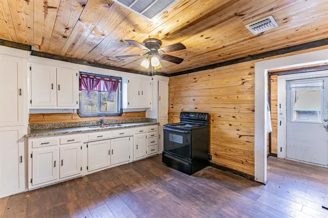 a kitchen with granite countertop a sink and cabinets