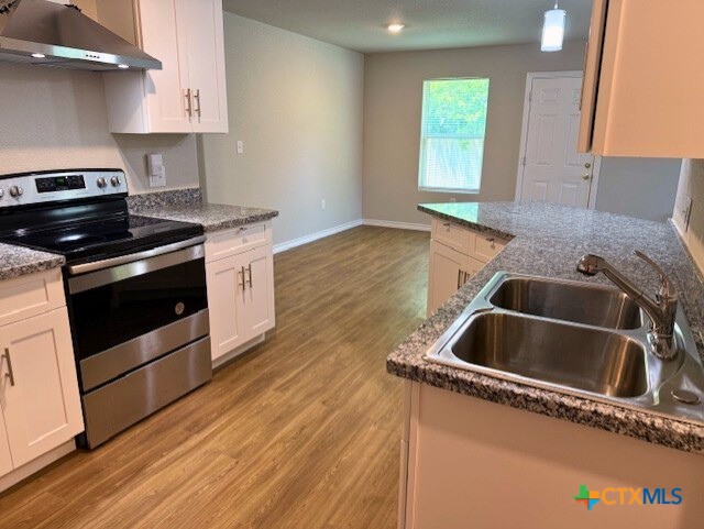 2410 Westcliff Road, Unit B Killeen, TX 76543 - Photo 4 of 21 a kitchen with granite countertop a sink and a stove top oven