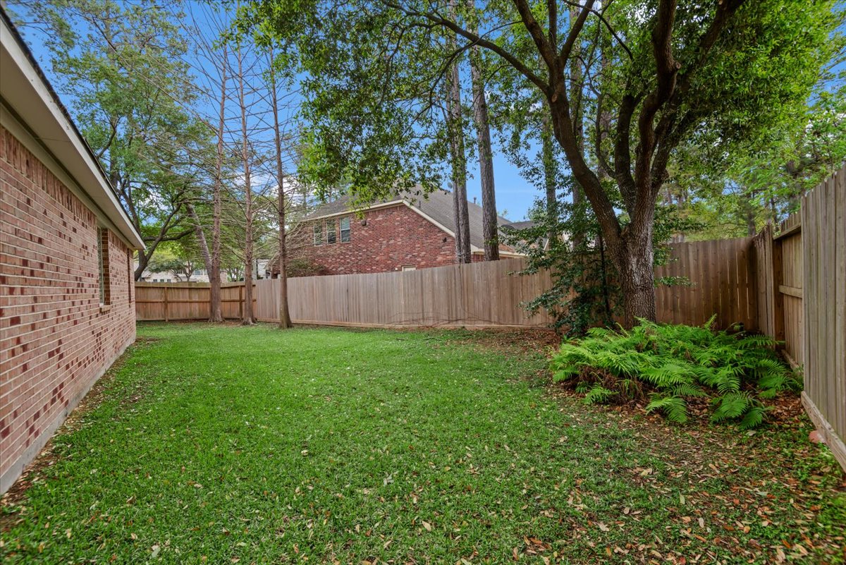 15519 Stallion Point Circle Cypress, TX 77429 - Photo 37 of 37 The property features a spacious yard with a well-maintained lawn, mature trees, and a privacy fence