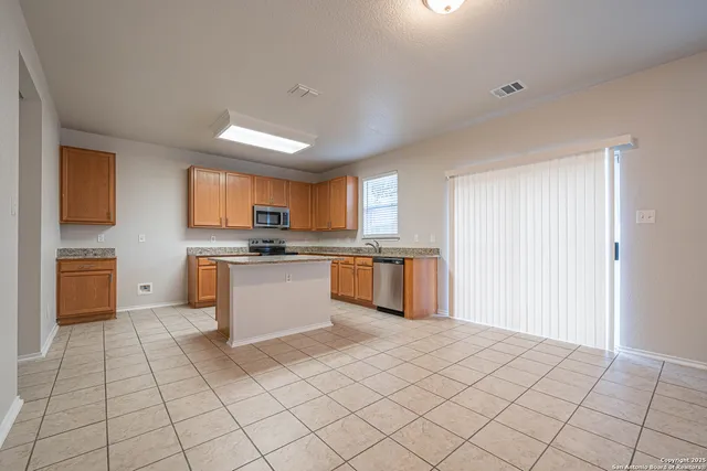 a large kitchen with a stove a sink dishwasher and a refrigerator