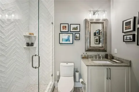 a bathroom with a granite countertop toilet sink and mirror