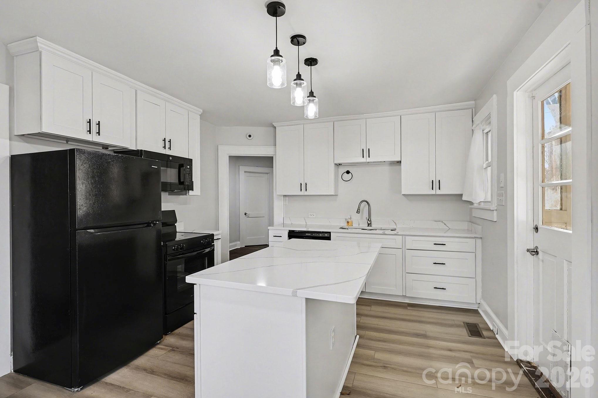 225 Valleyview Place Salisbury, NC 28144 - Photo 12 of 36 a kitchen with a refrigerator stove and white cabinets