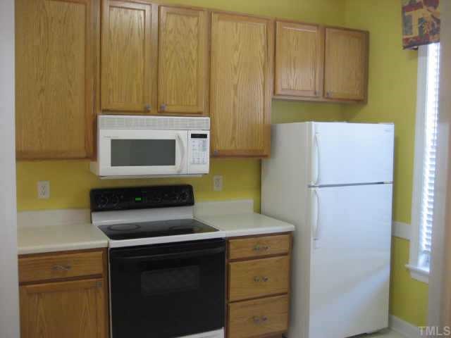 7318 Bonnie Ridge Court Raleigh, NC 27615 - Photo 2 of 9 a kitchen with a refrigerator stove and microwave