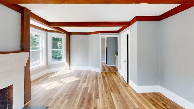 a view of empty room with wooden floor