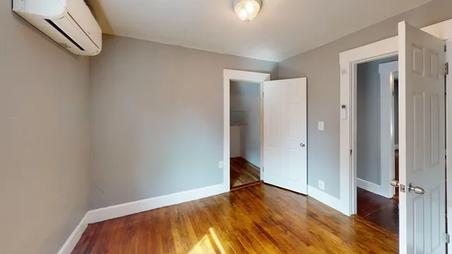 an empty room with wooden floor and closet