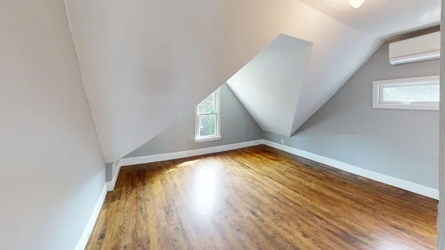 an empty room with wooden floor and a window