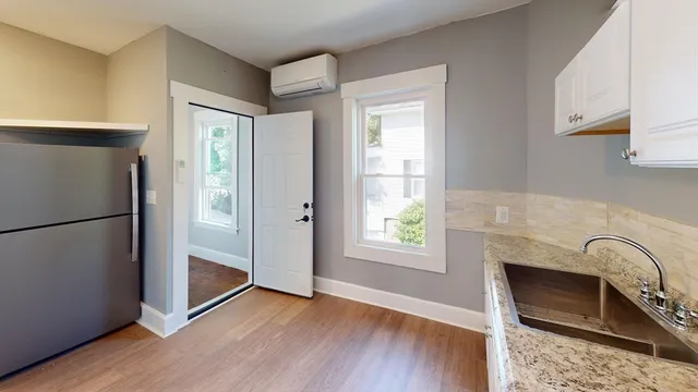 a view of a kitchen with wooden floor and a refrigerator