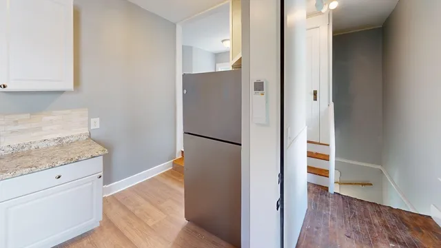an empty room with wooden floor and entrance