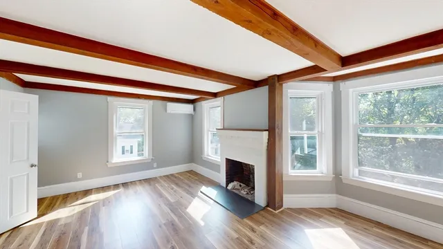 a view of an empty room with a window and a fireplace