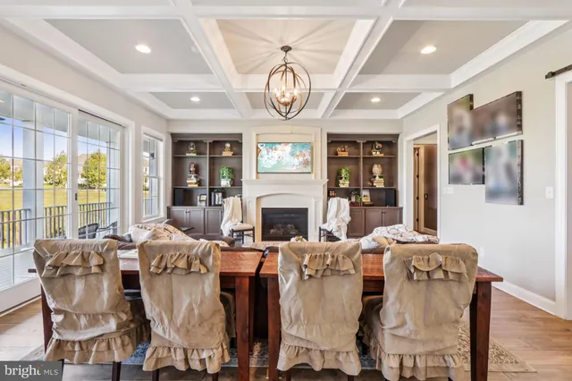 a kitchen with stainless steel appliances kitchen island granite countertop a stove a sink dishwasher and white cabinets with wooden floor