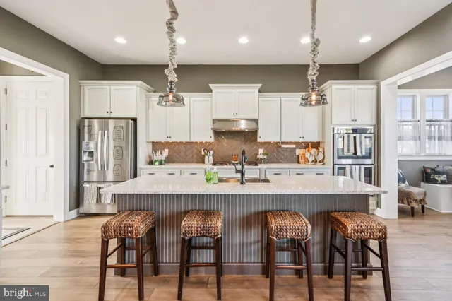 a kitchen with kitchen island granite countertop lots of counter top space a sink a window and stainless steel appliances