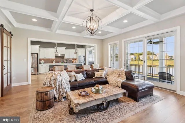 a large kitchen with a counter space a sink appliances and living room view