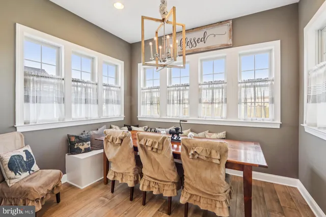 a bed sitting in a spacious bedroom next to a window with a chandelier and fireplace