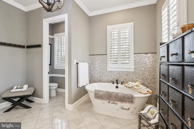 a spacious bedroom with a bed and a chandelier