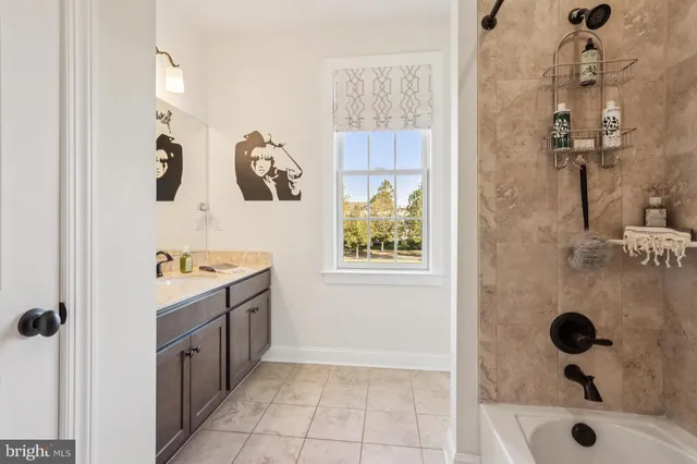 a living room with furniture a bookshelf and a window