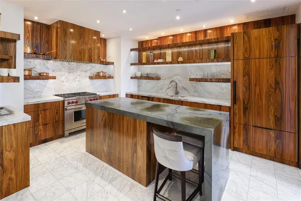 a kitchen with stainless steel appliances granite countertop a stove a sink and a refrigerator