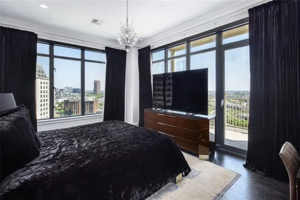 a bedroom with a bed lamps and a large window
