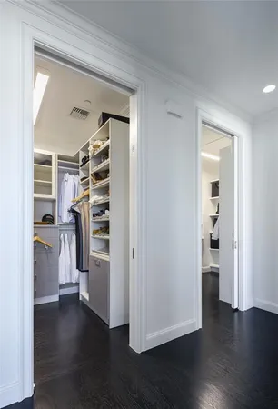 a view of walk in closet with wooden floor and a window