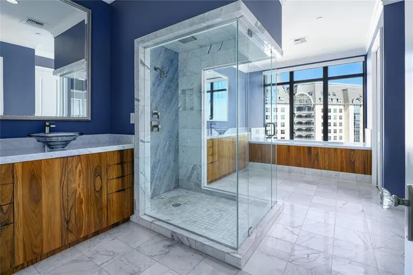 a spacious bathroom with a granite countertop sink mirror and a bathtub