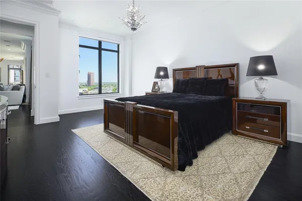 a living room with a bed furniture a fireplace and a flat tv screen on a dresser