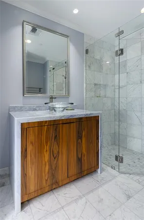 a bathroom with a granite countertop sink a mirror and shower