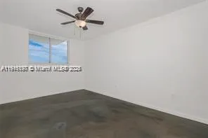 an empty room with a ceiling fan and a window