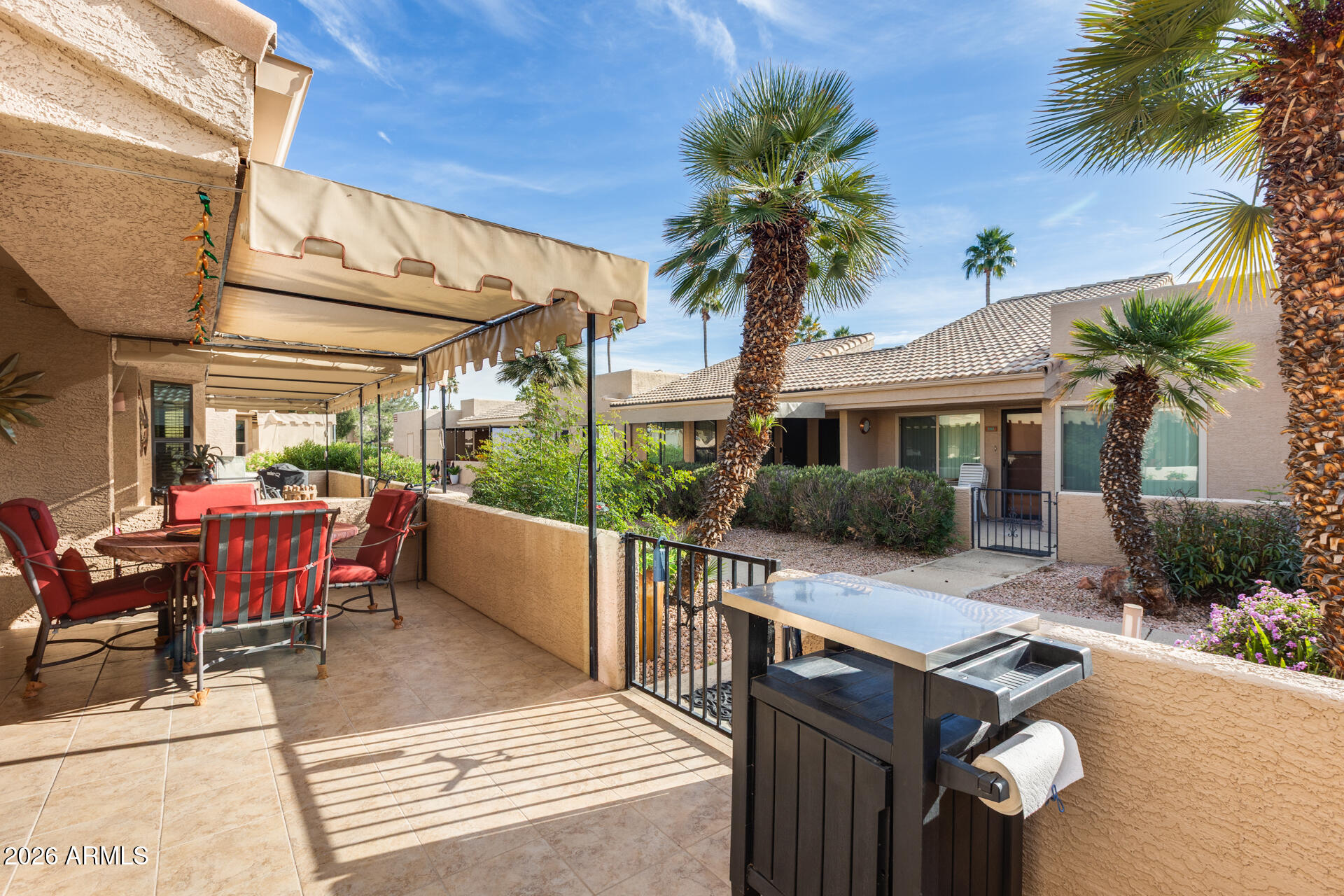 14300 West Bell Road, Unit 482 Surprise, AZ 85374 - Photo 2 of 53 a view of a patio with table and chairs potted plants and palm tree