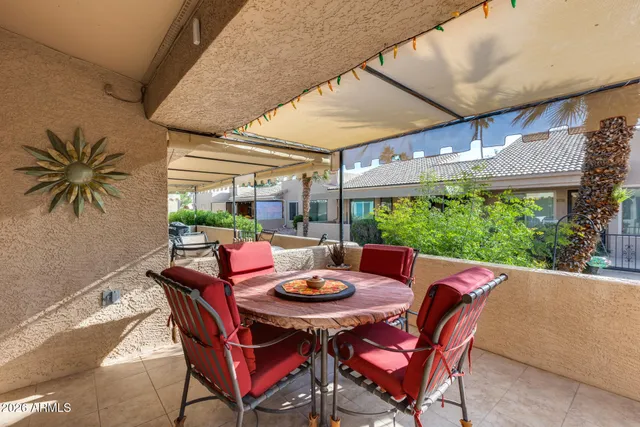 a view of a patio with chairs and a barbeque