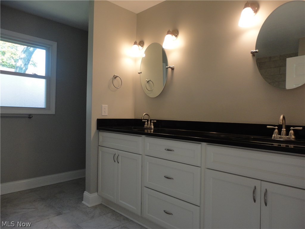 19646 Prospect Road Strongsville, OH 44149 - Photo 17 of 32 Master bath with dual sinks and mirrors, granite counter tops, ceramic flooring and tiled walls. Complete with separate shower from bath.