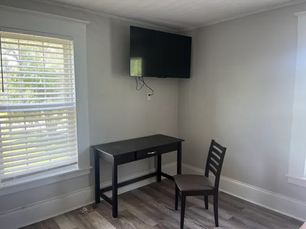 a view of a workspace with furniture and a window