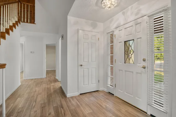 a view of front door with wooden floor and stairs