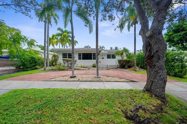 a front view of a house with a yard and potted plants